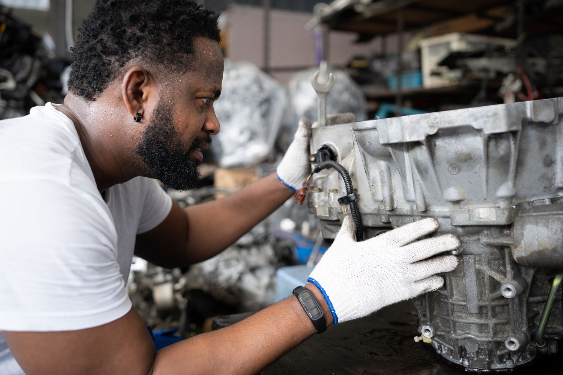 Mechanic in white gloves inspecting a car engine in a workshop