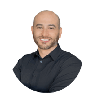 Smiling bald man in a dark shirt with folded arms on a white background