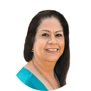 Studio headshot of a smiling person with long dark hair wearing a teal top on a white background