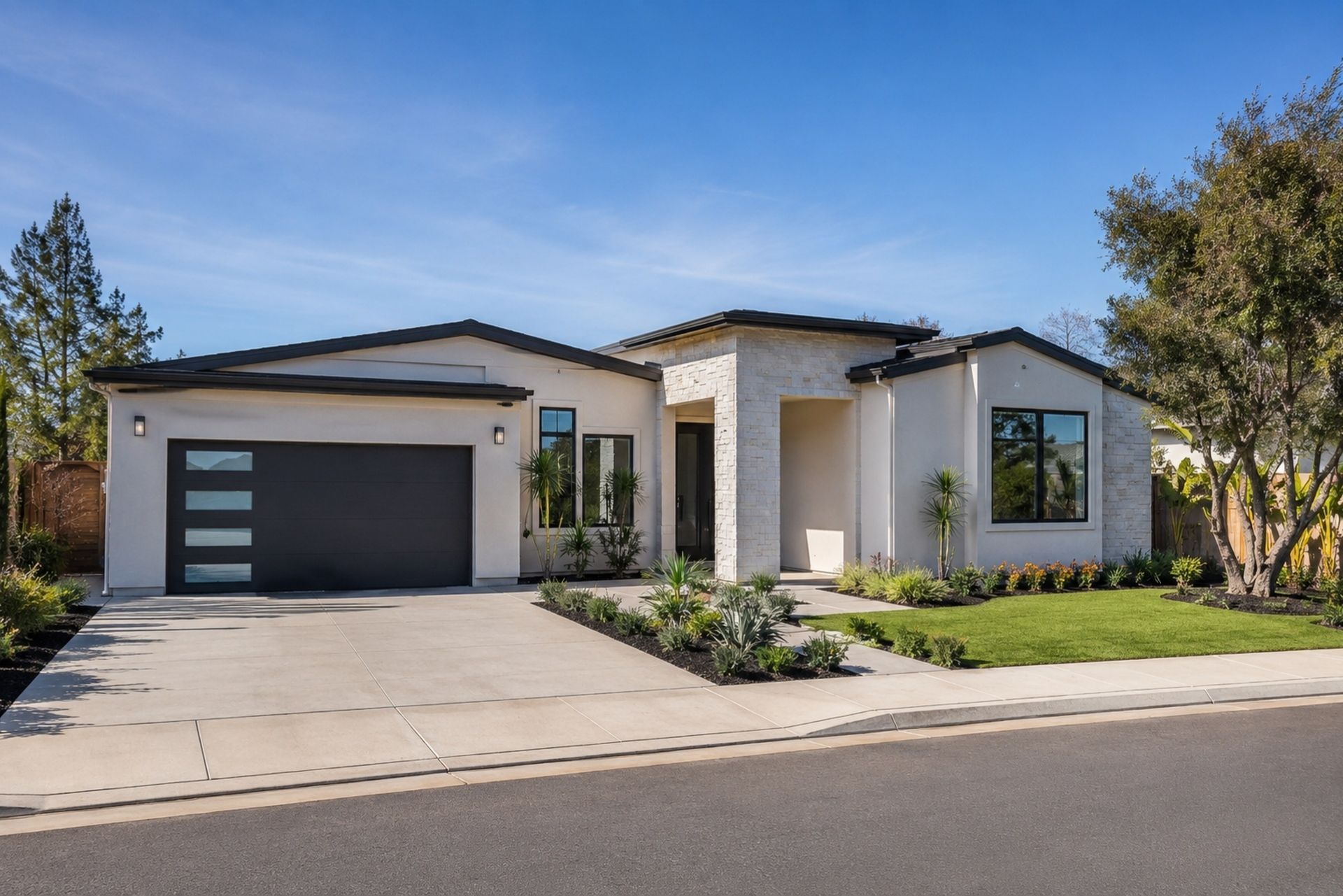Brick garage with a dark roll-up door in a paved driveway, surrounded by trees and shrubs.