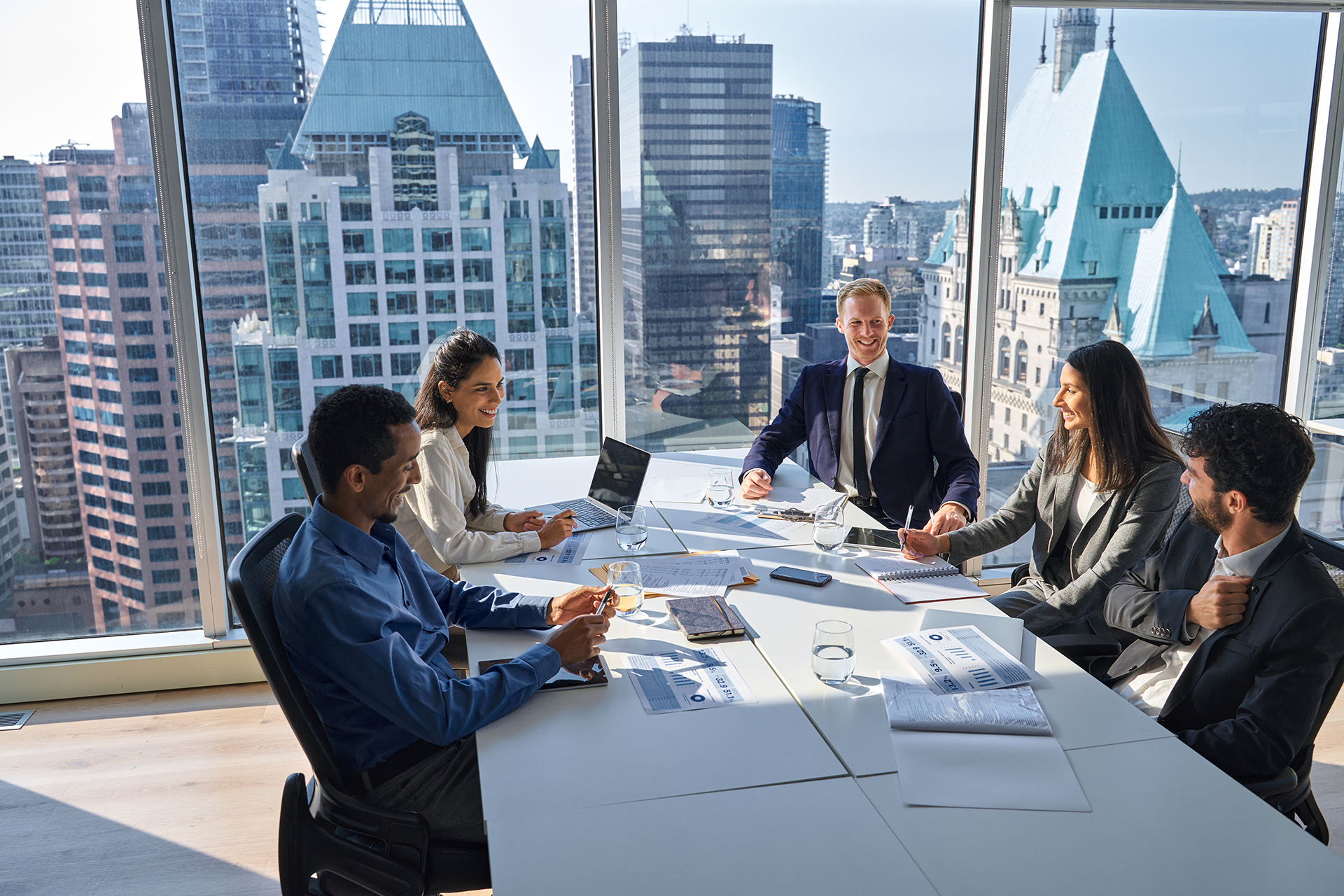 Business team meeting in a bright high-rise conference room with a city skyline view