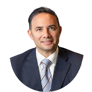Headshot of a man in a dark suit and striped tie on a white background