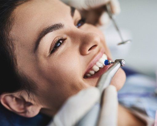 Close-up of a smiling dental patient with braces being examined by a dentist