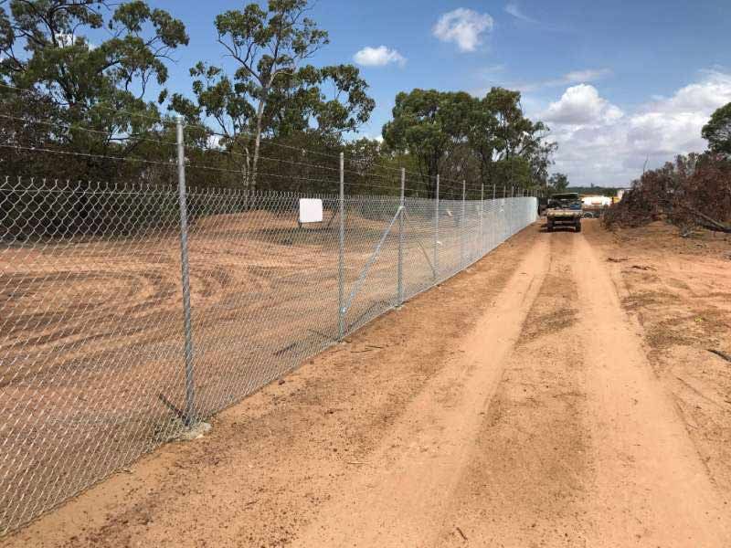 A Chain Link Fence Is Along The Side Of A Dirt Road — Mulch, Fencing And Landscaping Mackay, QLD