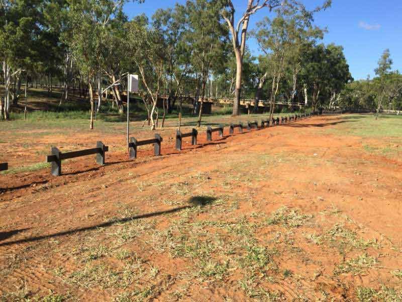 A Dirt Road With A Wooden Fence And Trees In The Background — Mulch, Fencing And Landscaping Mackay, QLD