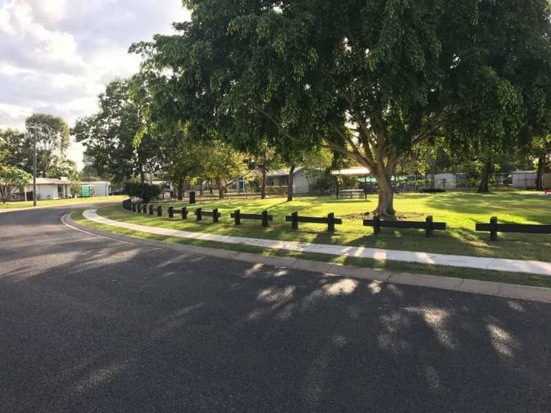 A Wooden Fence Surrounds A Park In A Residential Area — Mulch, Fencing And Landscaping Mackay, QLD