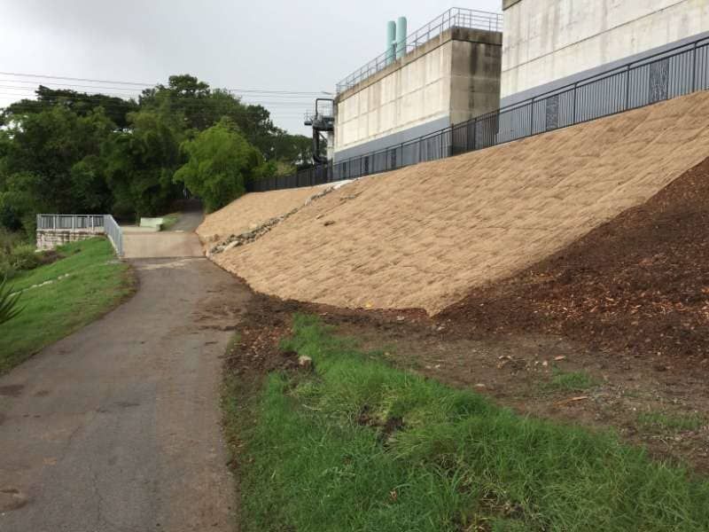 A Dirt Road Going Up A Hill Next To A Building — Mulch, Fencing And Landscaping Mackay, QLD