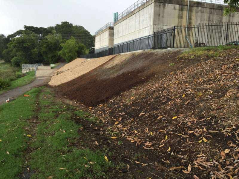 A Dirt Hill With A Fence And A Building In The Background — Mulch, Fencing And Landscaping Mackay, QLD