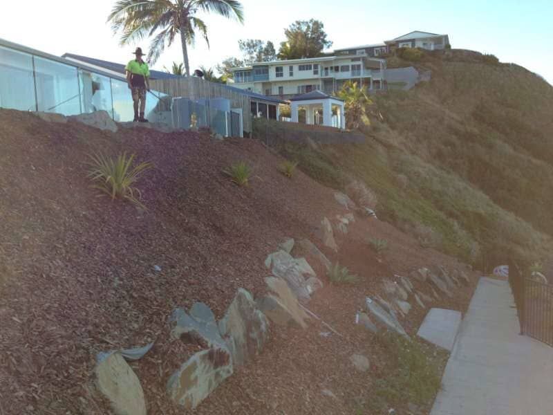 A Man Standing On Top Of A Hill With A House In The Background — Mulch, Fencing And Landscaping Mackay, QLD