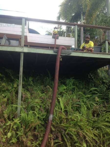 A Man Is Sitting On A Deck With A Hose Attached To It— Mulch, Fencing And Landscaping Mackay, QLD