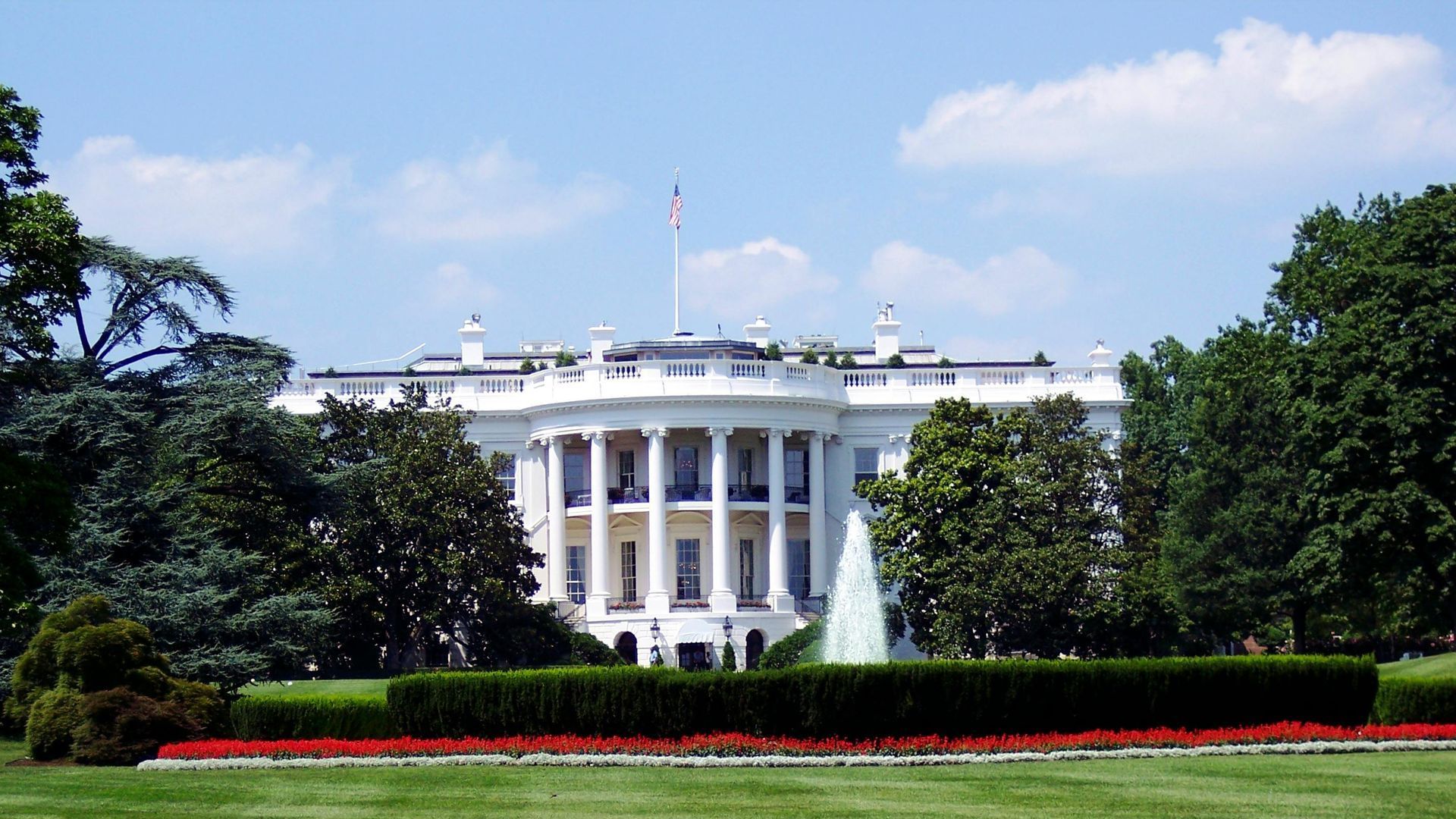 The white house has a fountain in front of it