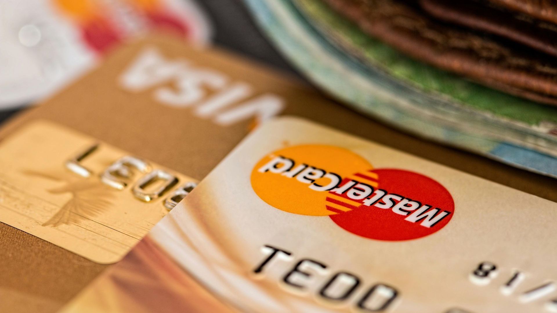 A close up of a mastercard and visa credit card on a table.