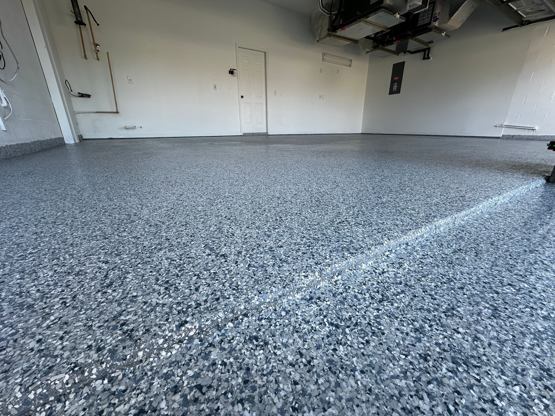 A garage with a gray floor and white walls.