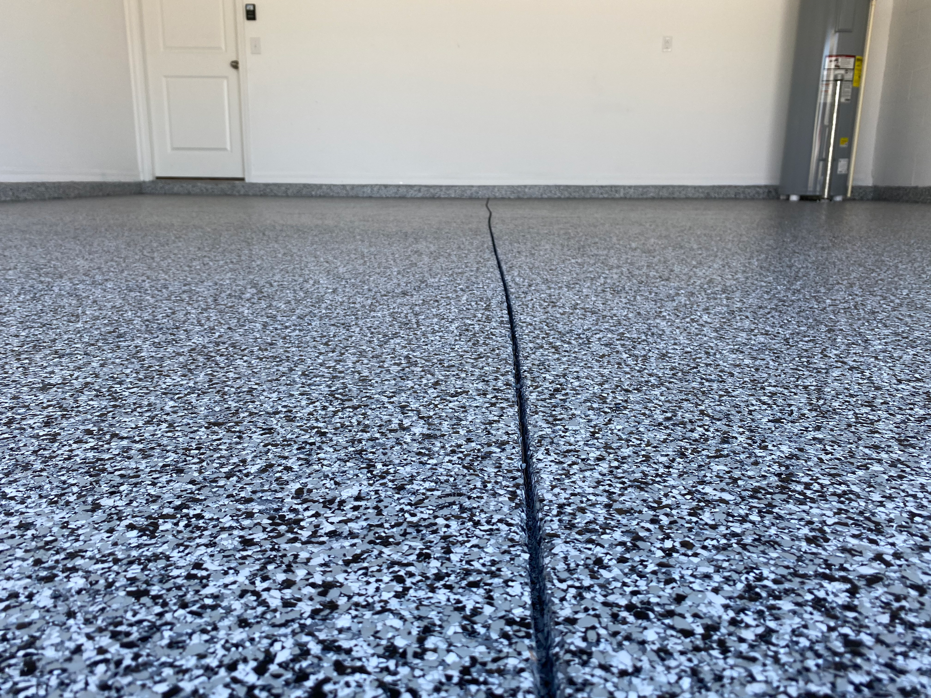 A close up of a garage floor with a ladder in the background.