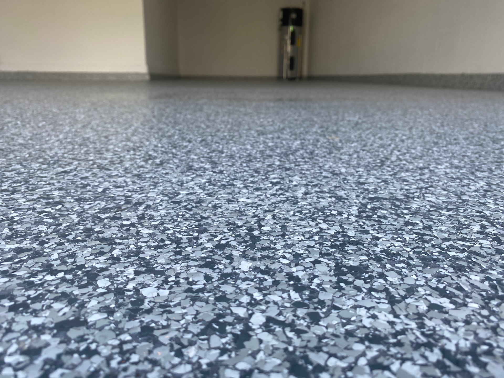 A close up of a gray and white flake floor in a garage.