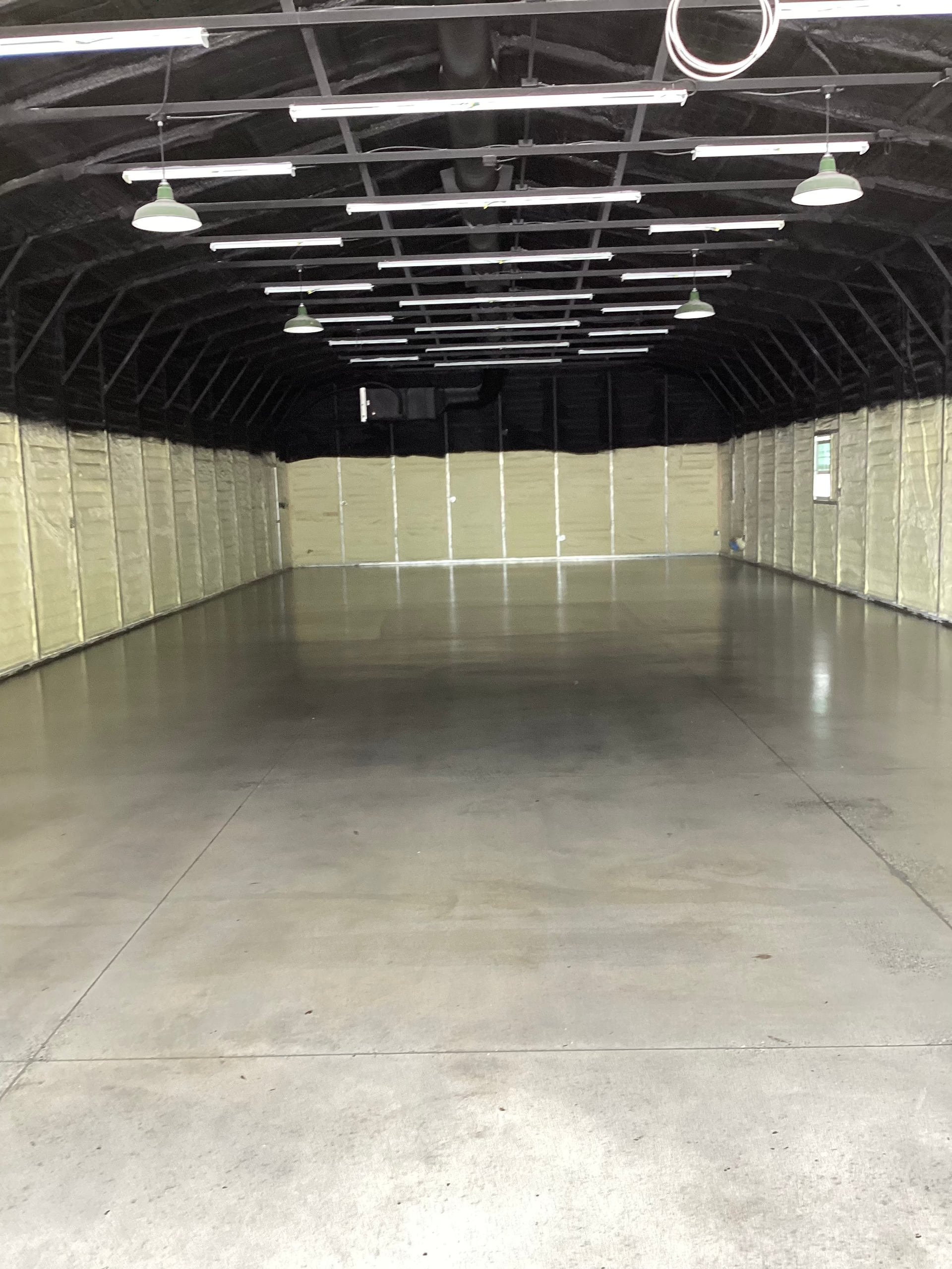 A large empty warehouse with a concrete floor and ceiling.