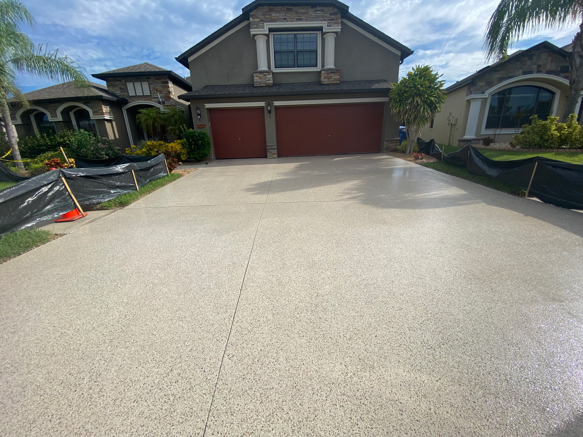 A driveway leading to a large house with two garages.