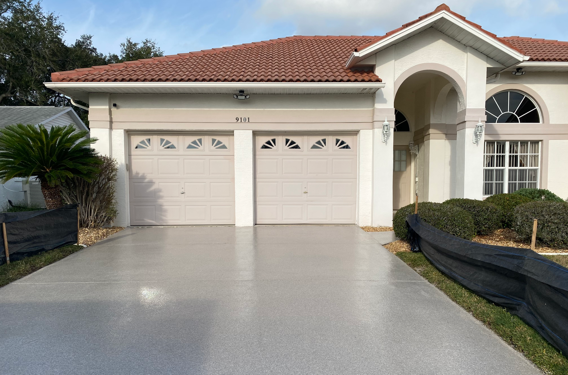 A white house with a concrete driveway in front of it.