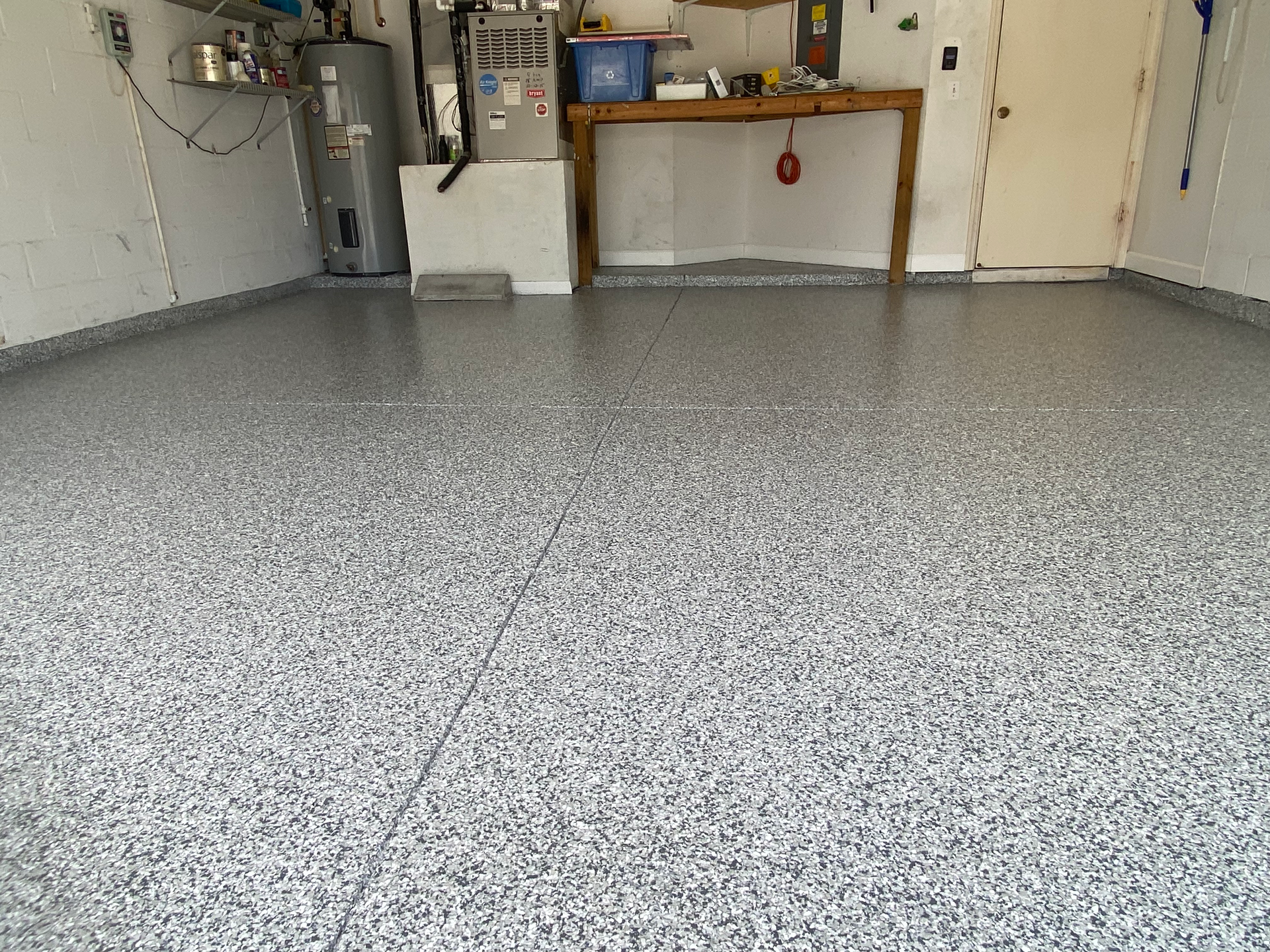 A garage with a gray floor and a wooden table.