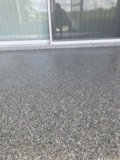 A concrete floor with a sliding glass door in the background.