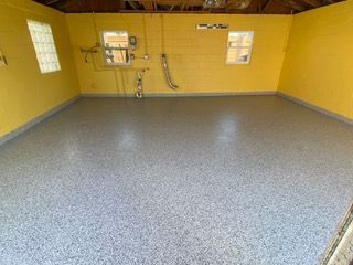 A garage with a gray floor and yellow walls.