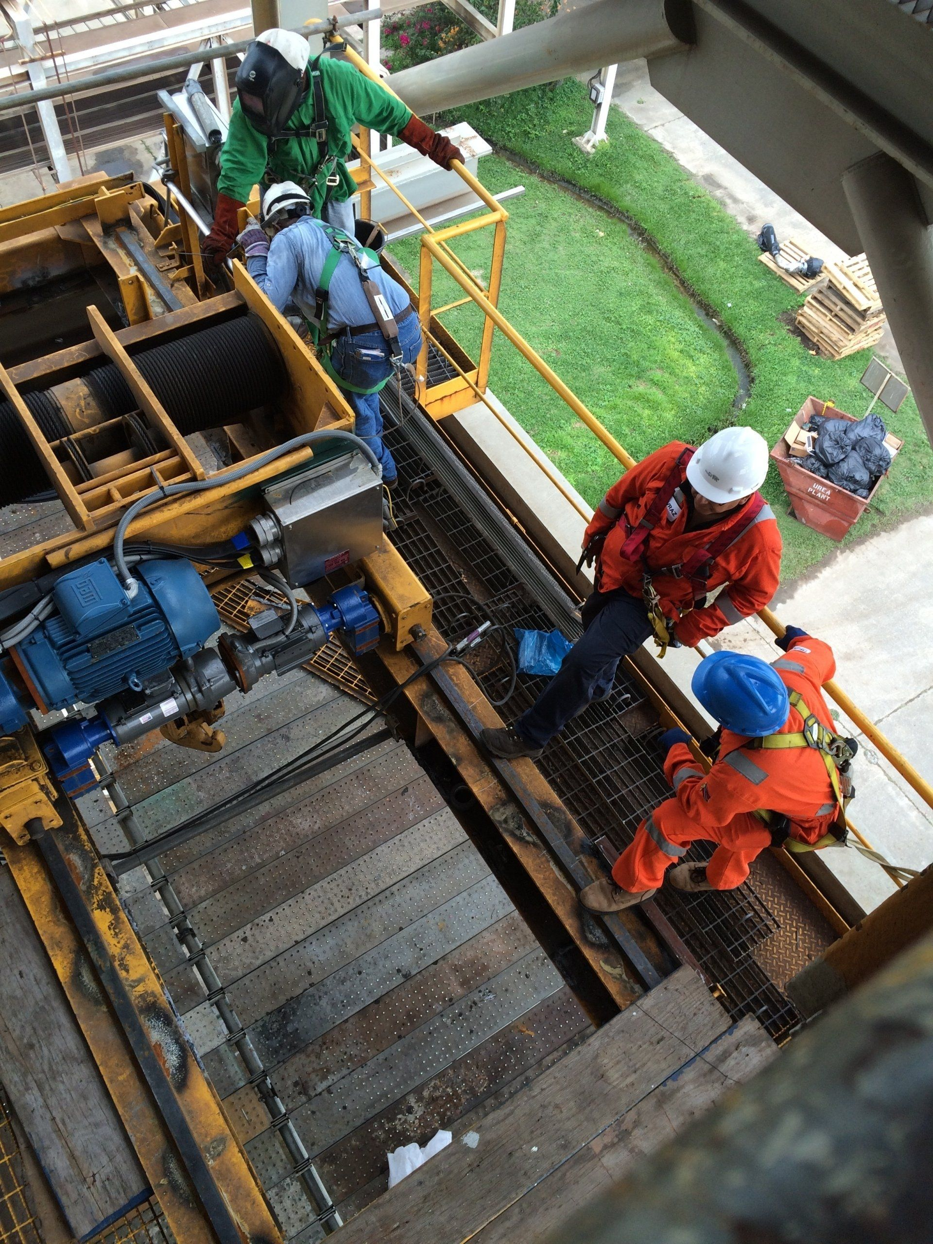 A group of construction workers are working on a machine.