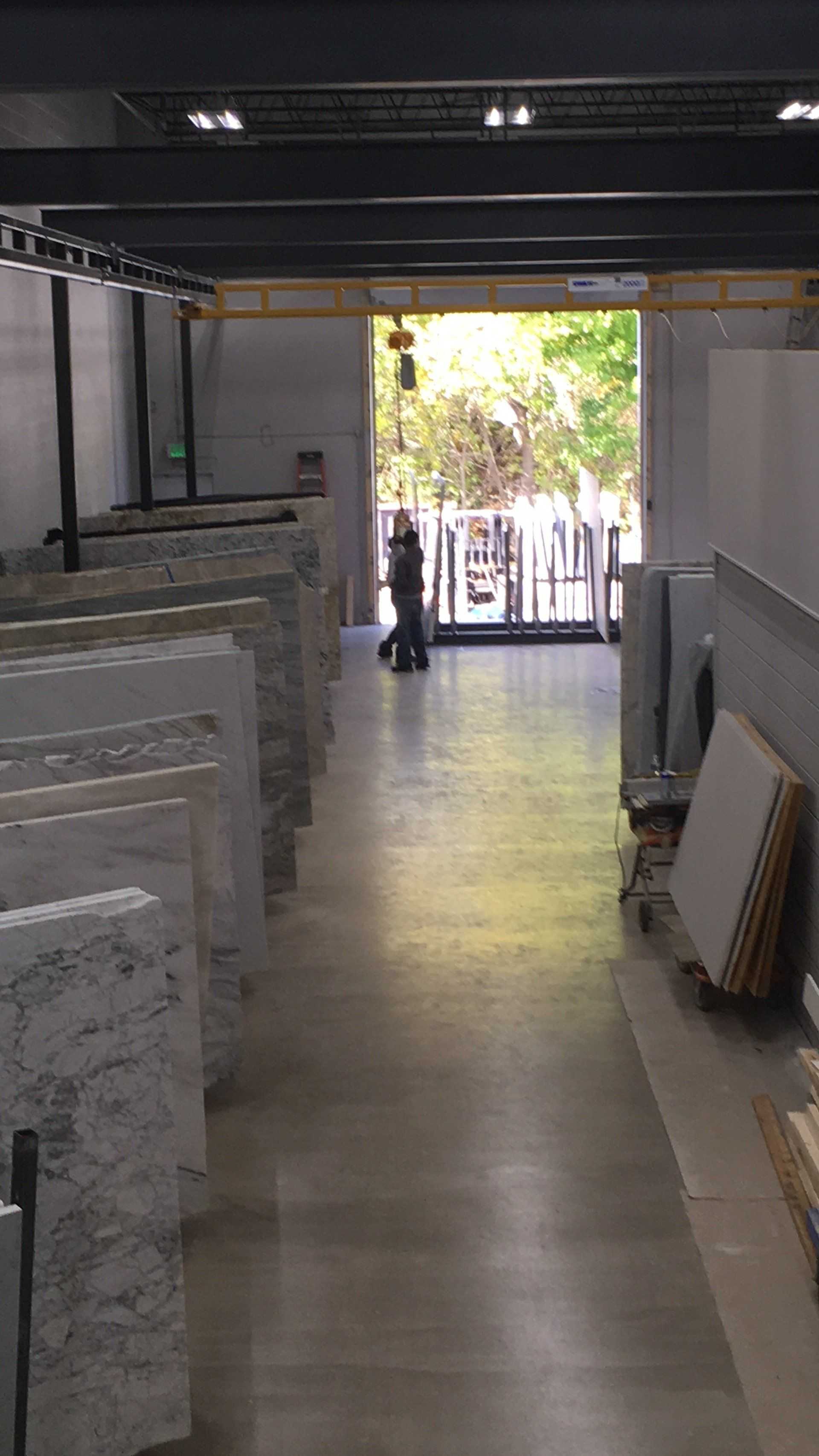 A row of marble slabs are lined up in a warehouse.