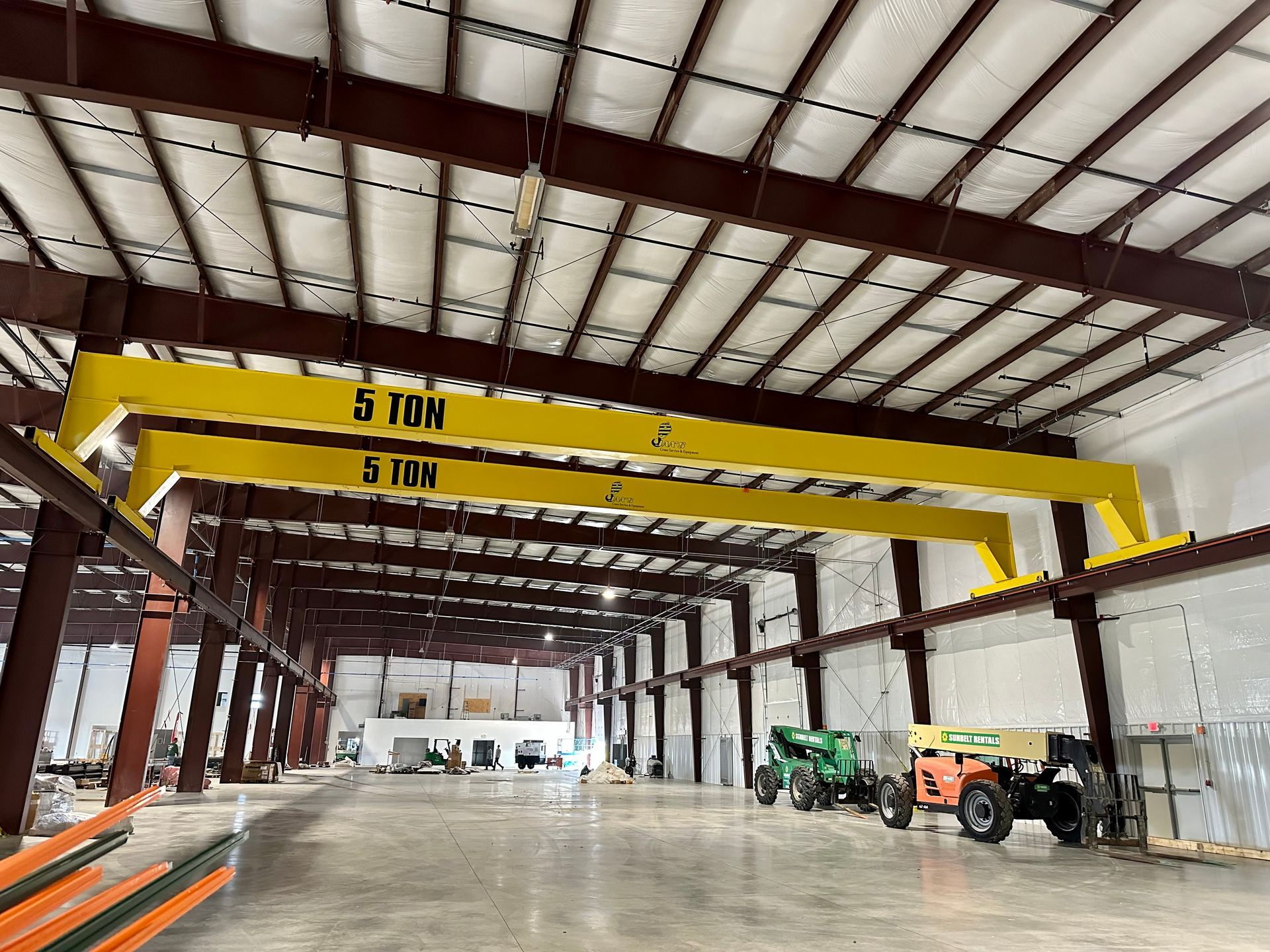 A large warehouse with a crane in the middle of it.