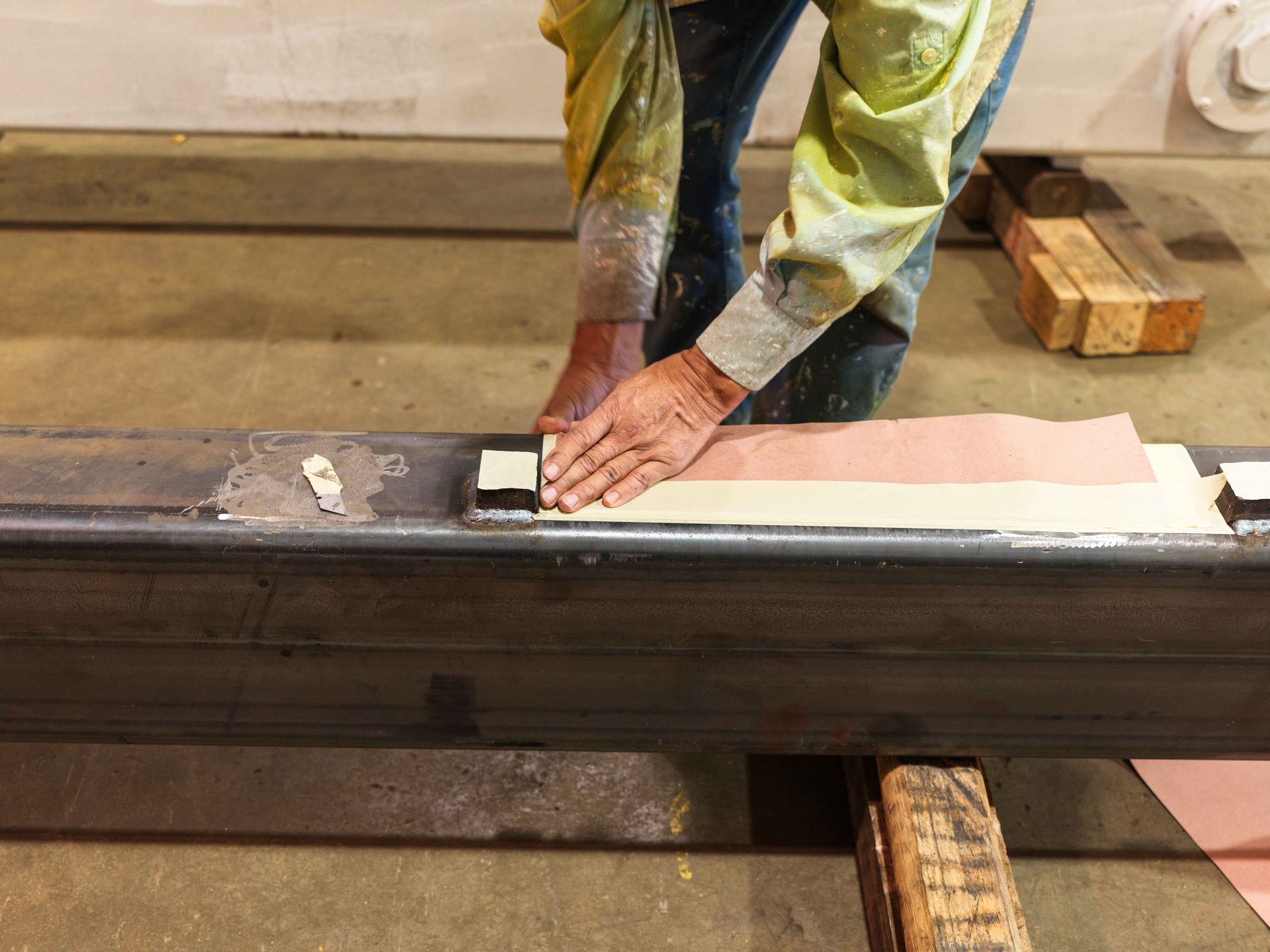 A man is working on a piece of metal in a factory.