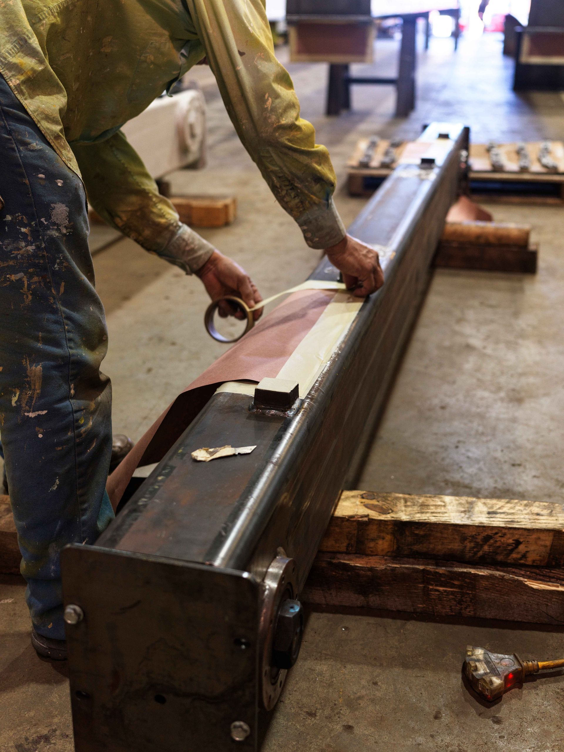 A man is working on a large piece of metal