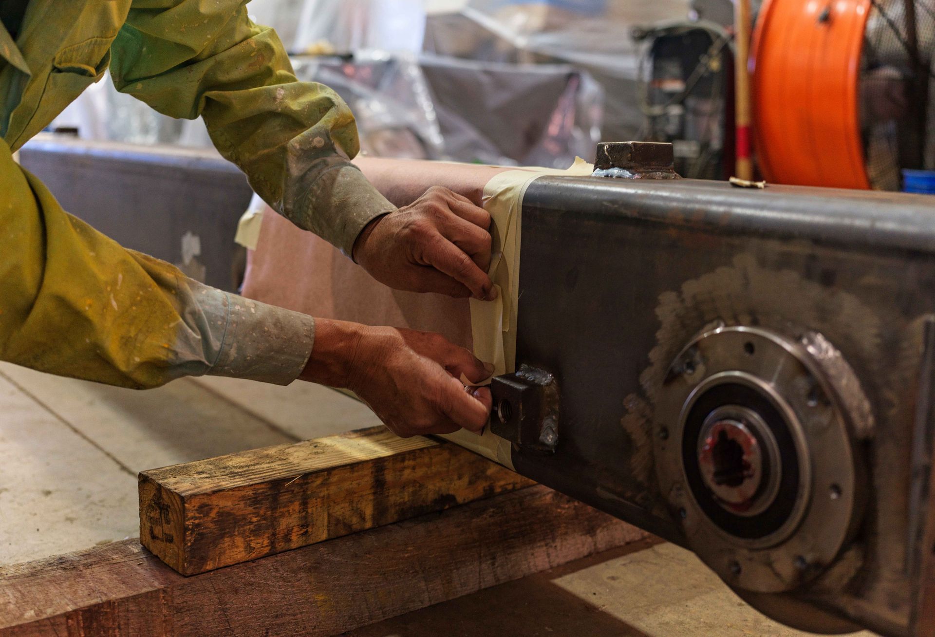A man is working on a piece of metal in a workshop.