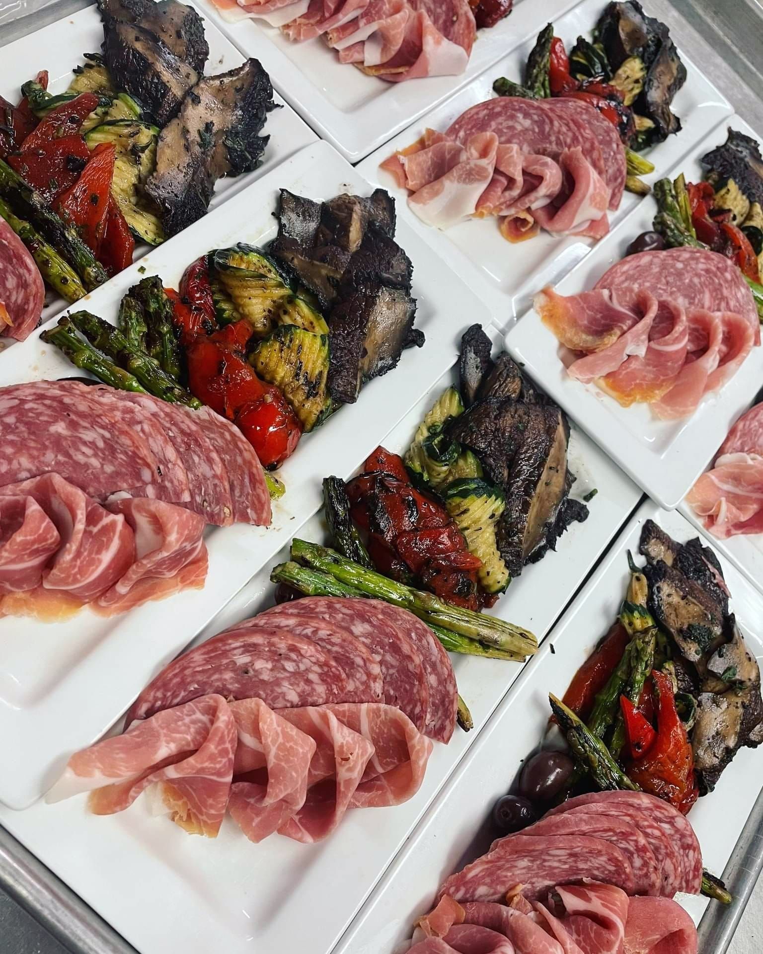 Assorted plated gourmet dishes on a wooden table, seen from above.
