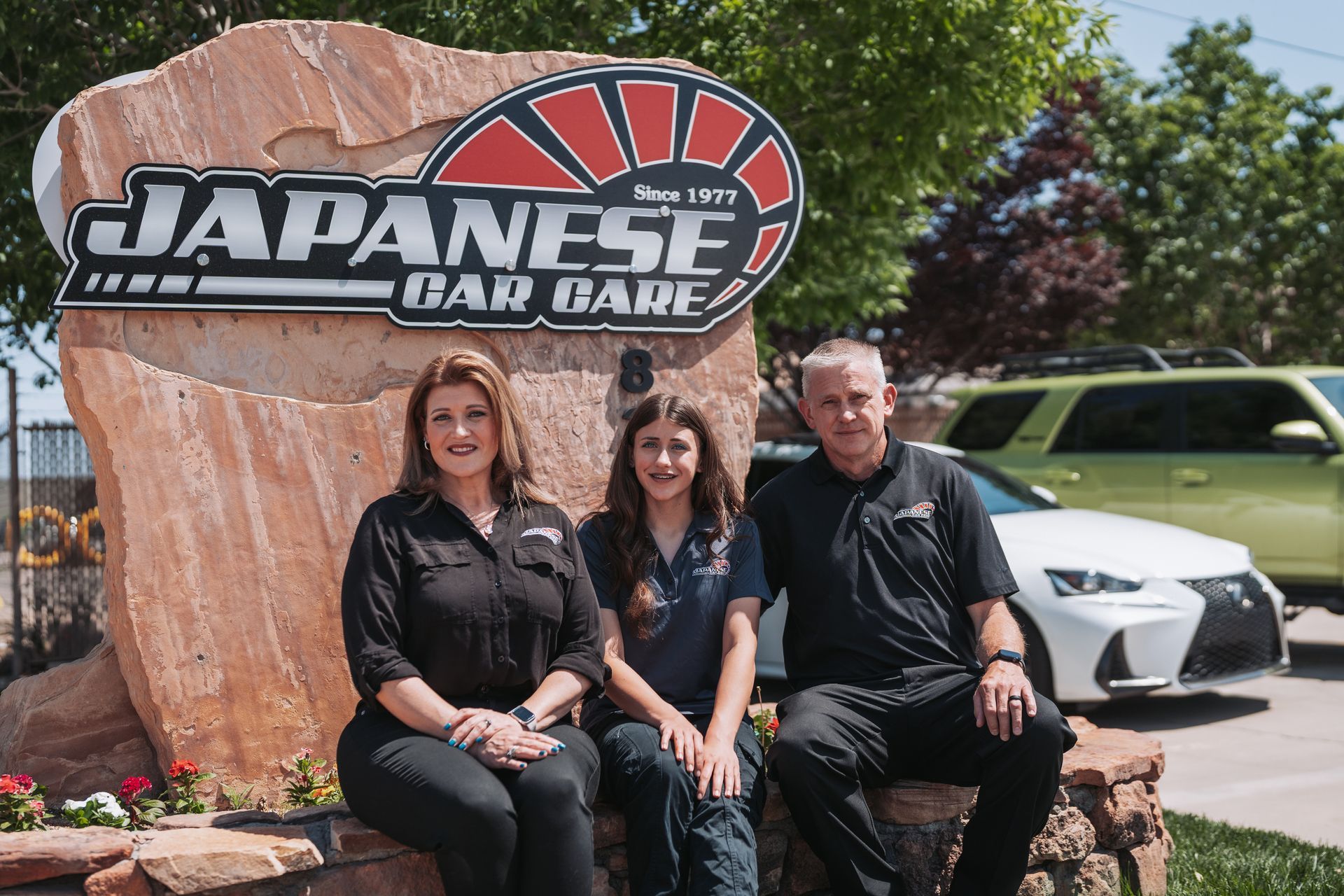 A family is posing for a picture in front of a japanese car dealership. | Japanese Car Care