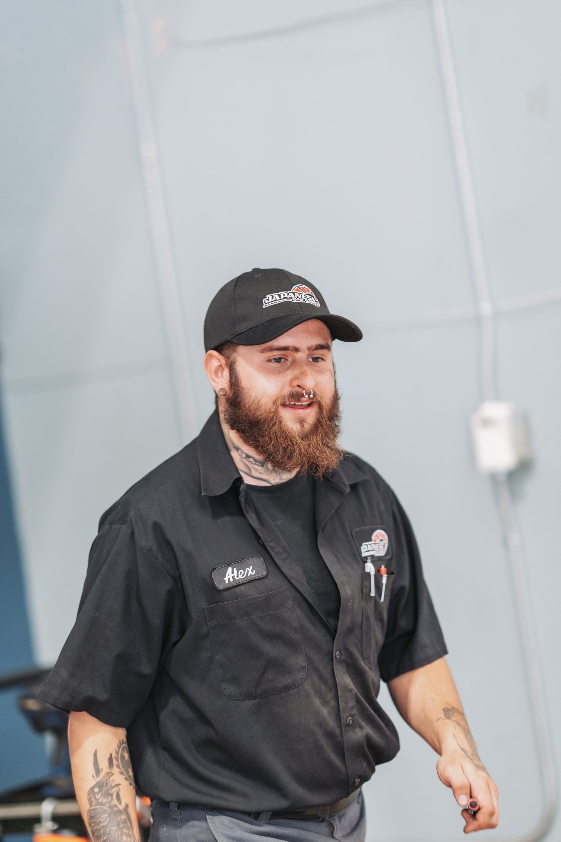 A man with a beard is wearing a hat and a black shirt. | Japanese Car Care