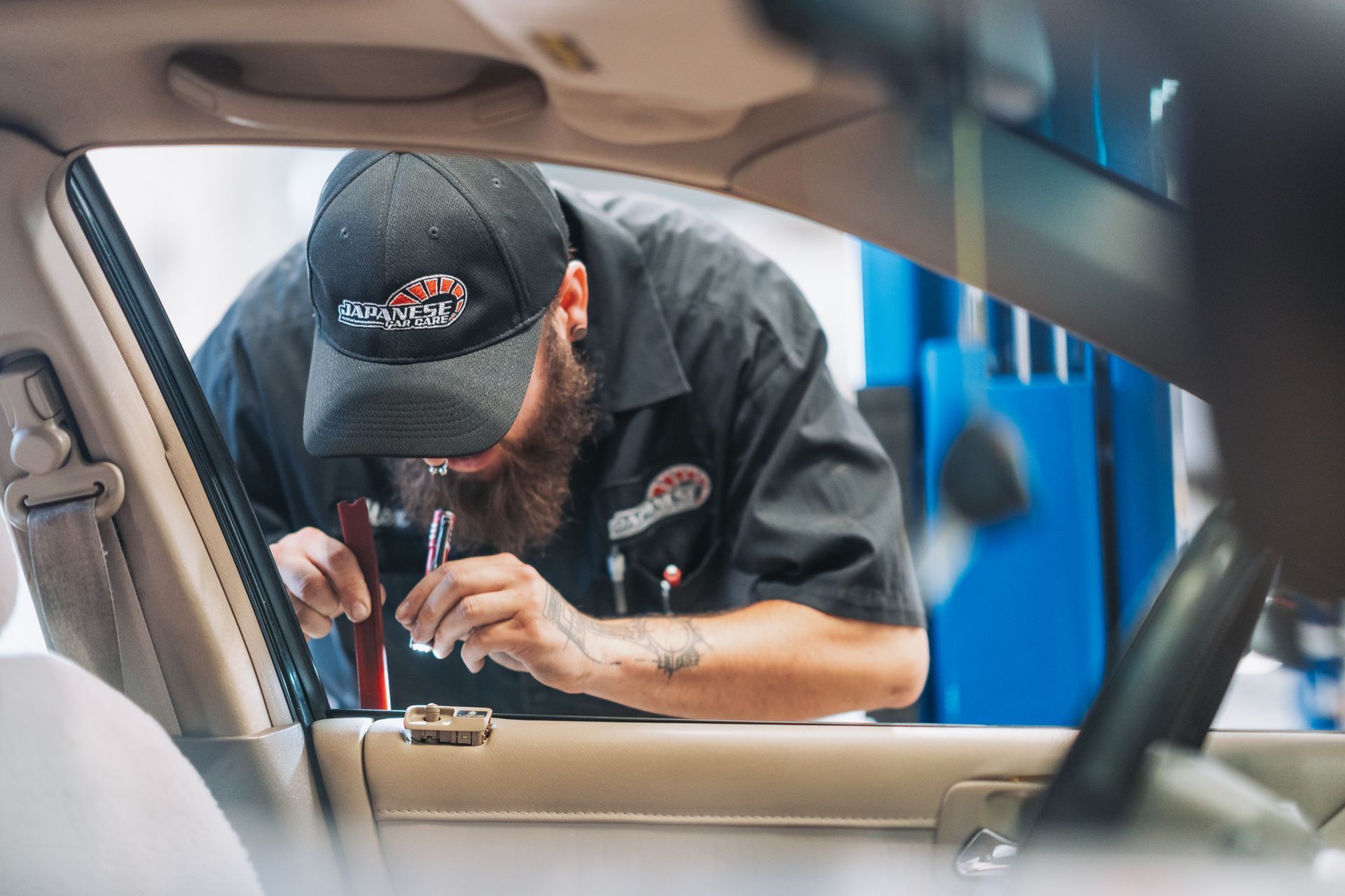 A man is working on the door of a car. | Japanese Car Care