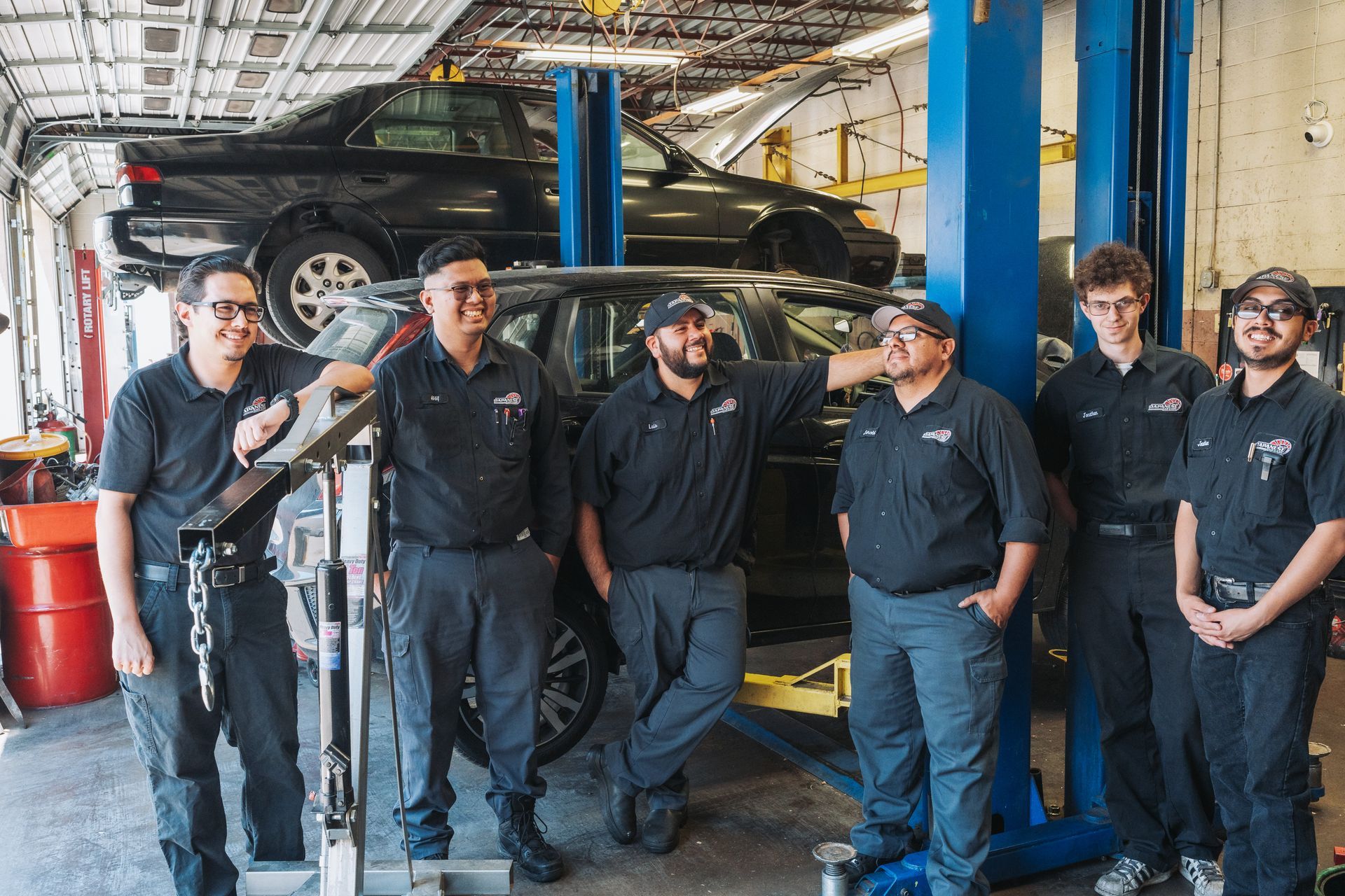A group of mechanics are posing for a picture in a garage. | Japanese Car Care