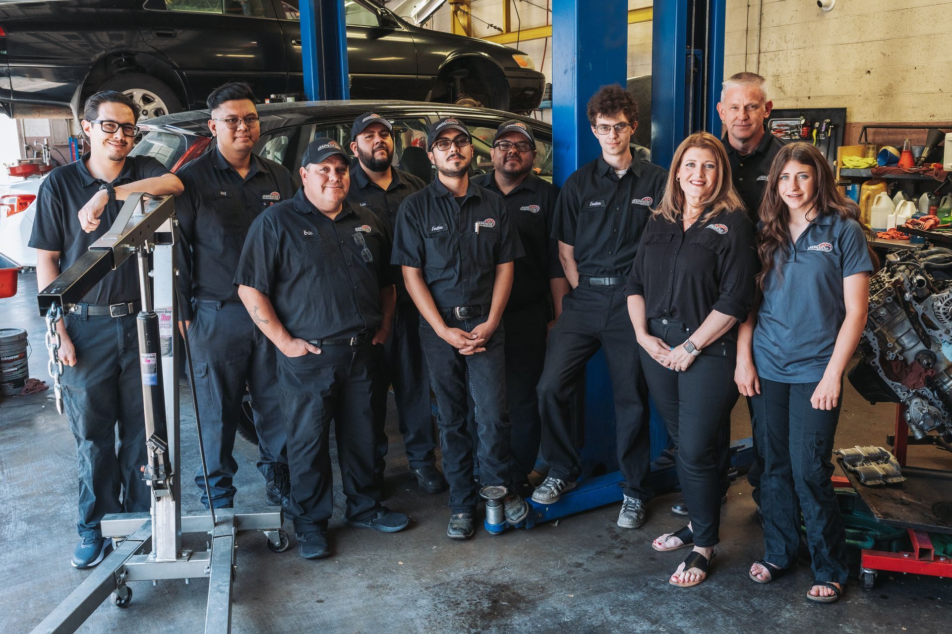 A group of mechanics are posing for a picture in a garage. | Japanese Car Care
