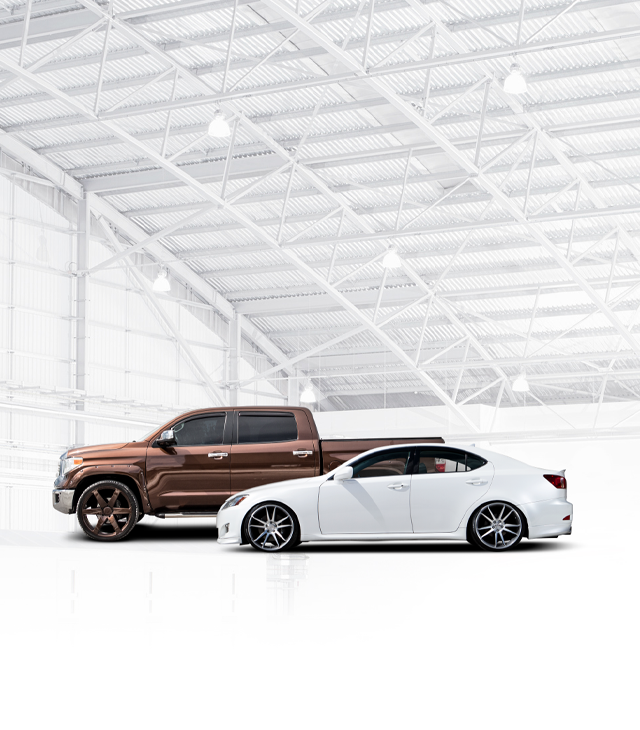 A truck and a car are parked next to each other in a garage. | Japanese Car Care