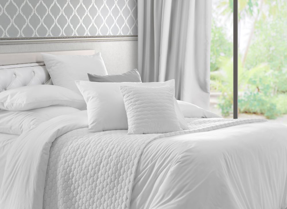 A Bed With White Sheets and Pillows in a Bedroom — Super Suds Laundry in Avoca, QLD