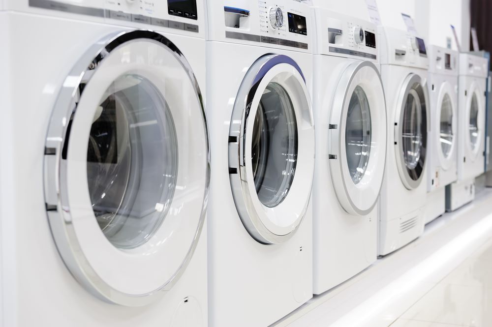 A row of white washing machines are lined up in a laundromat — Super Suds Laundry in Avoca, QLD