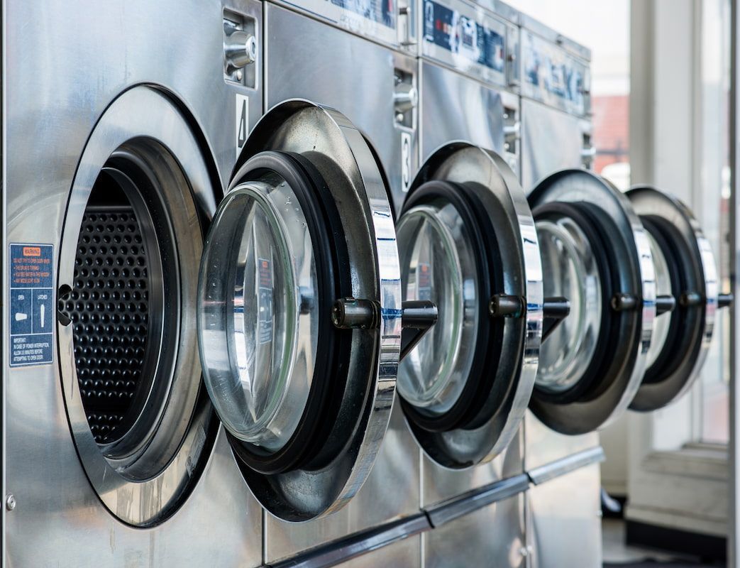 A Row of Washing Machines Are Lined up In a Laundromat — Super Suds Laundry in Avoca, QLD