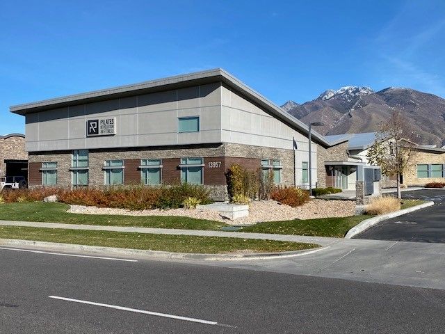 A large building with a lot of windows and mountains in the background
