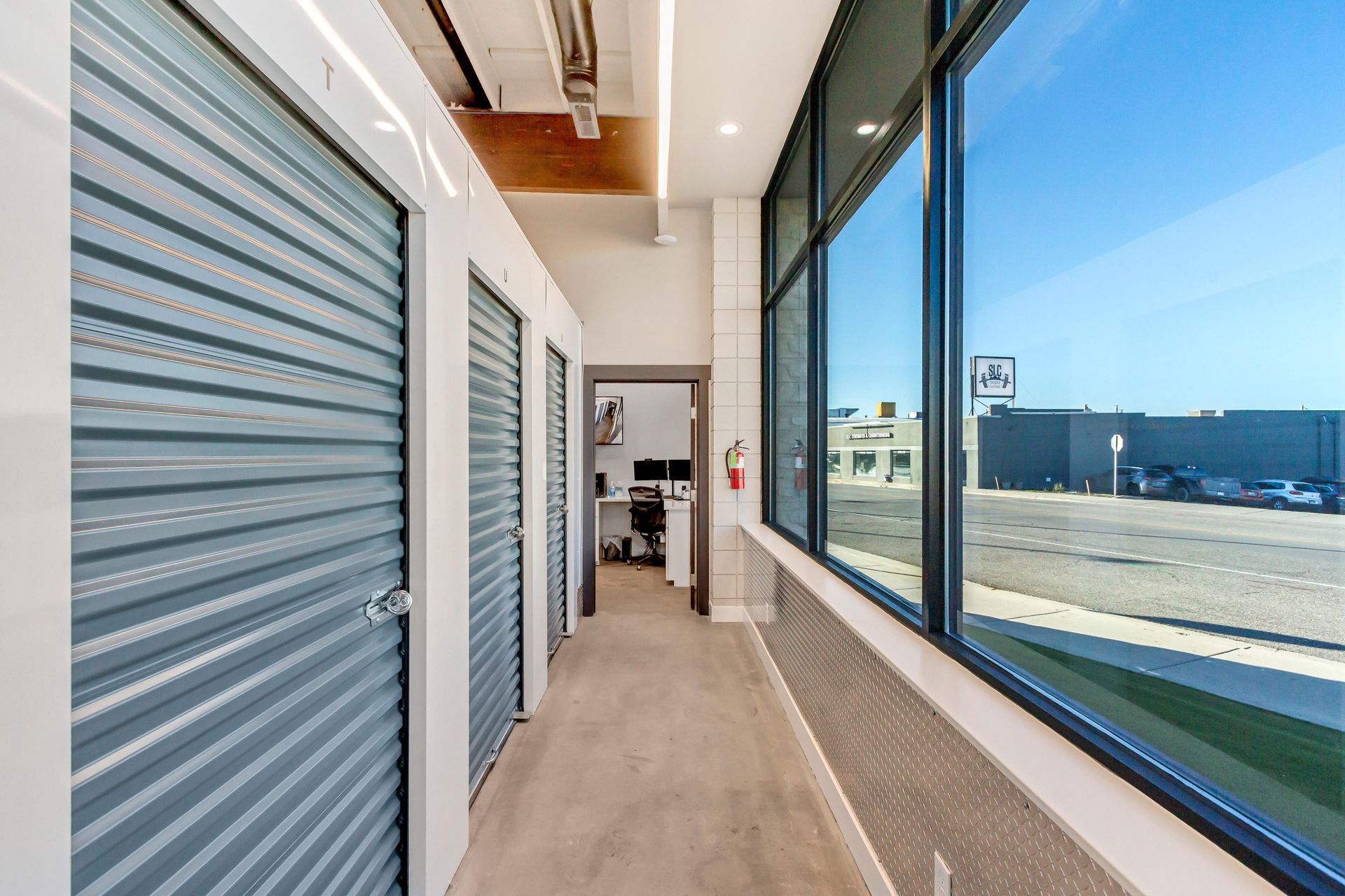 A long hallway with a lot of windows and storage units.
