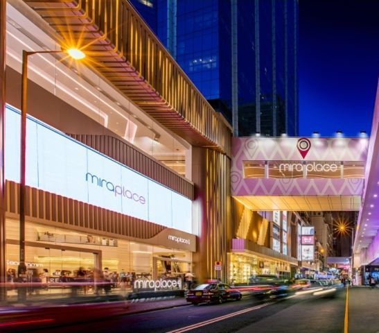 夜晚的 Mira Place 購物中心,金色外觀,燈光明亮,街道下方車水馬龍。