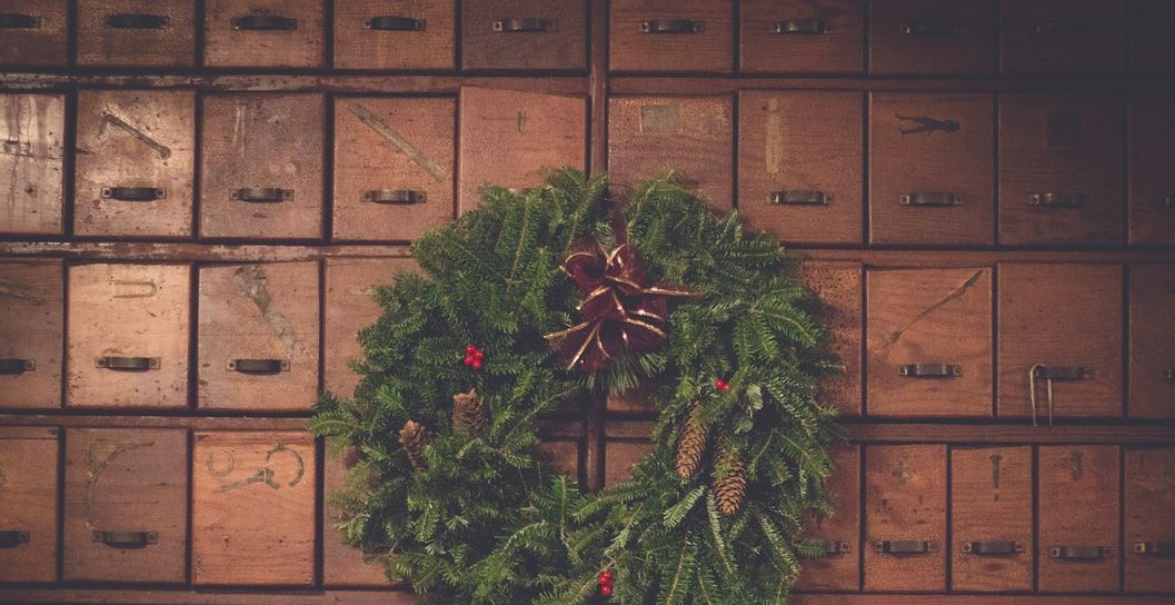 Holiday wreath hanging on a wall of wooden mailboxes