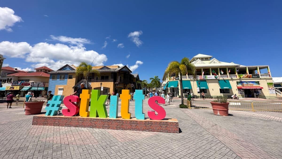 Colorful #Skittles letters in a sunny plaza with palm trees, blue sky, and buildings behind them