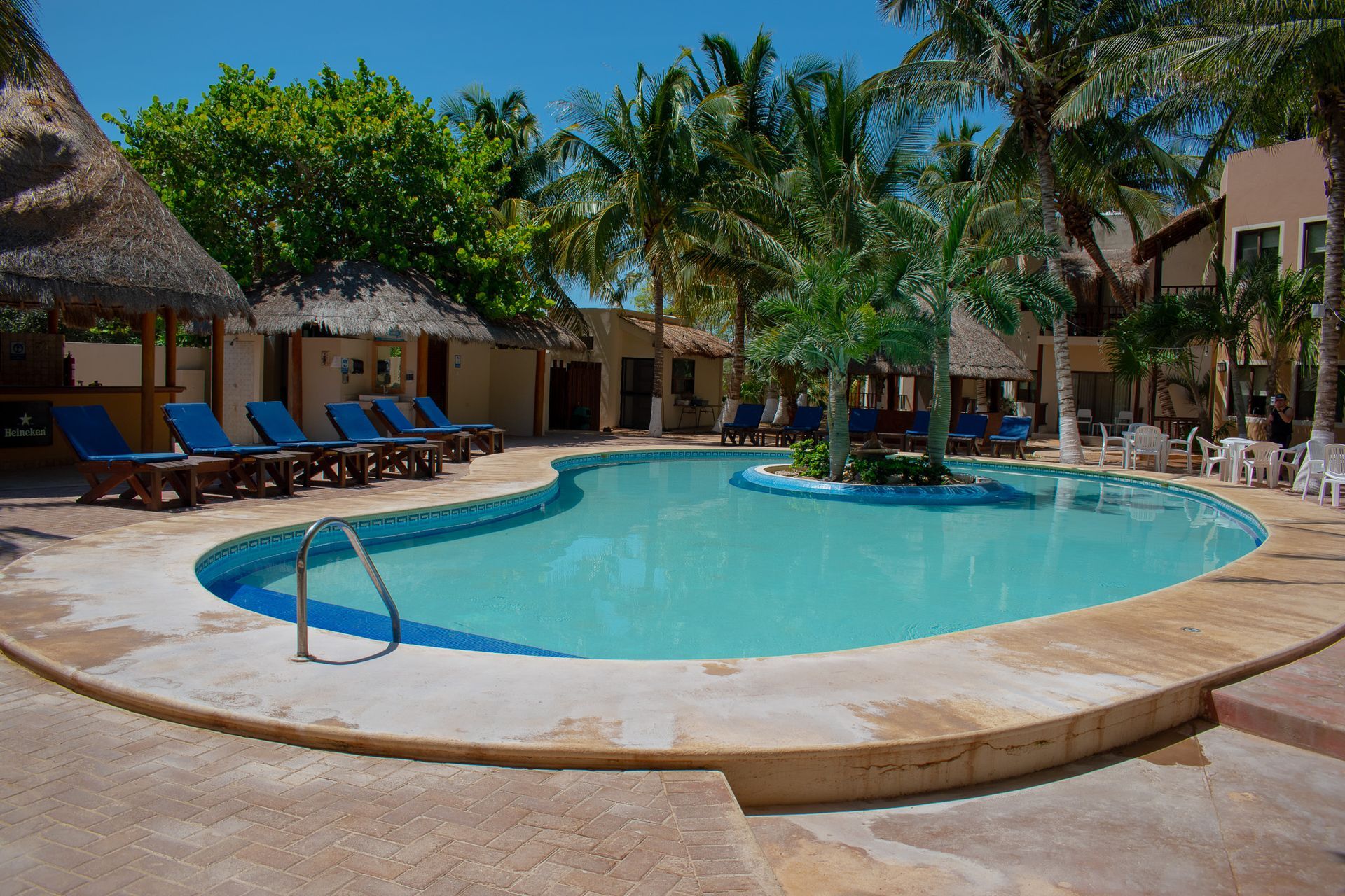 Una gran piscina rodeada de sillas y palmeras en Tecnohotel Beach