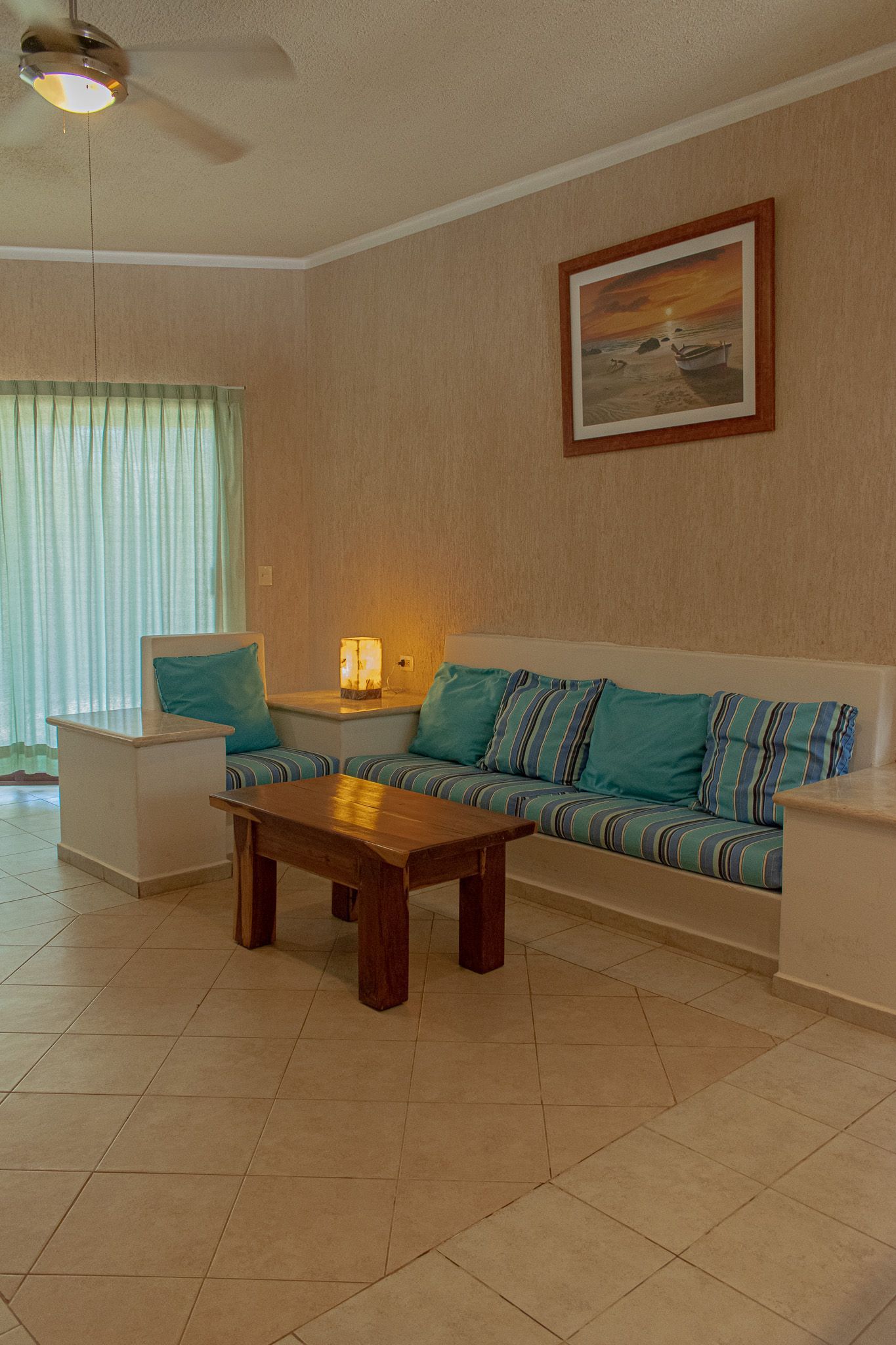 Una sala de estar con sofá, silla, mesa y ventilador de techo en Tecnohotel Beach.