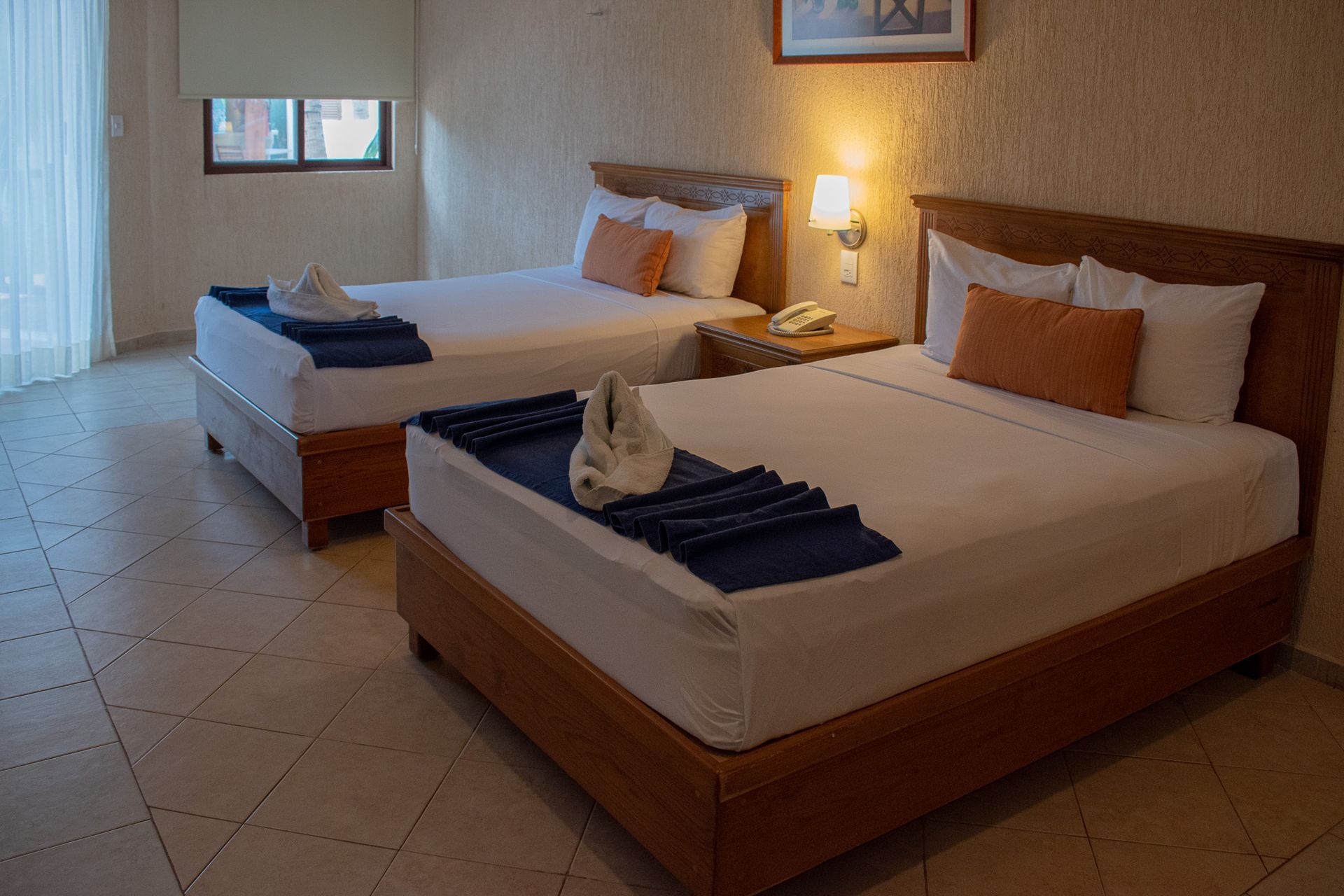 Una habitación de hotel con dos camas y una ventana.
