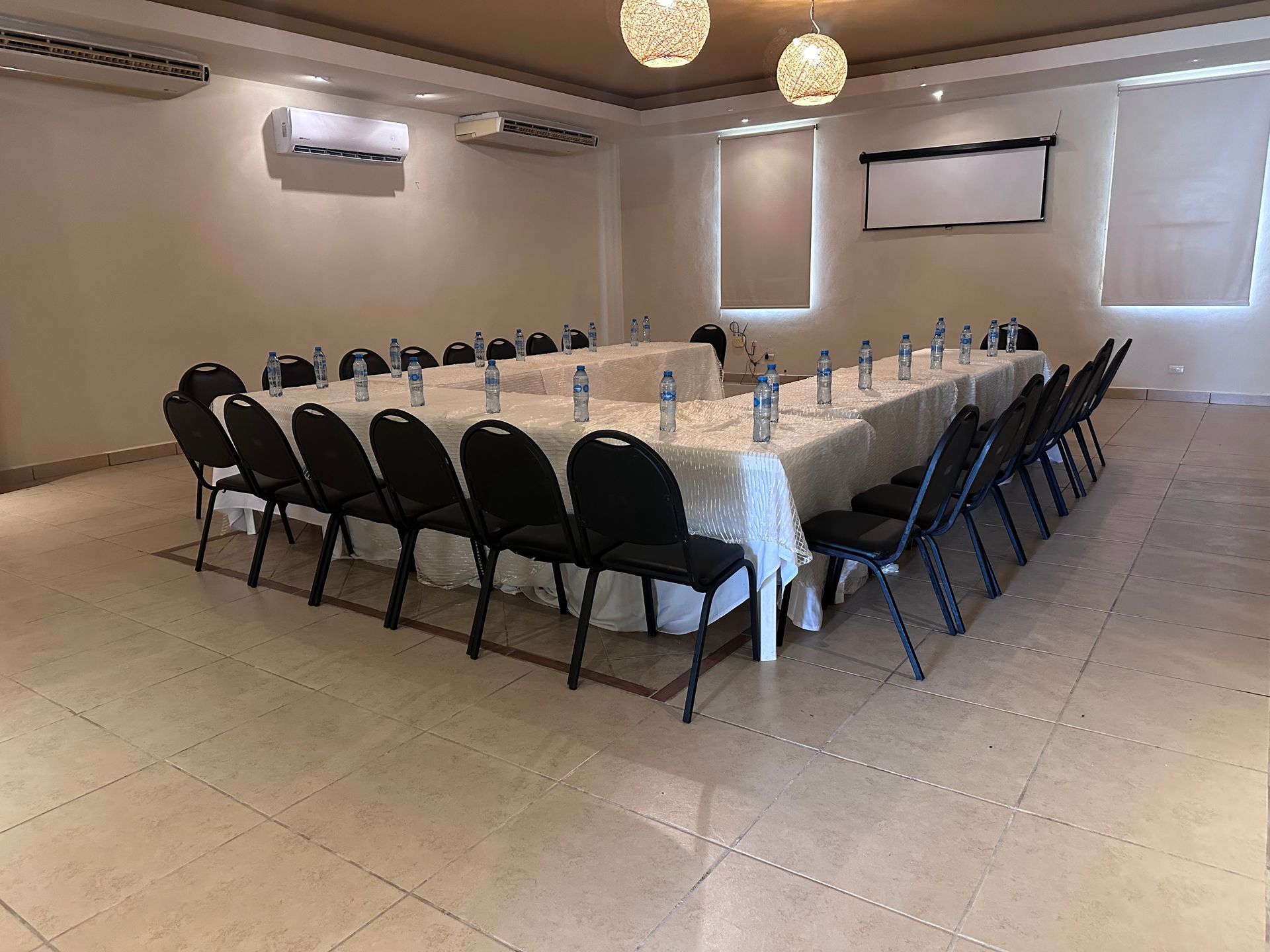 Una sala de conferencias con una mesa larga y sillas preparadas para una reunión en Tecnohotel Beach